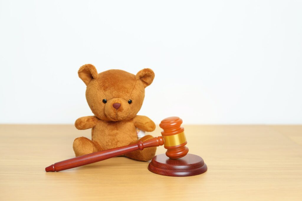Children, Kid and Family Law concepts. toy bear with gavel justice hammer on desk in courthouse.